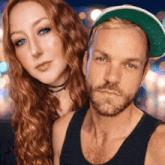 a man with a beard and a woman with red hair are posing for a photo
