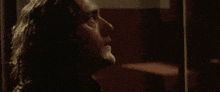 a close up of a man 's face in a dark room looking up