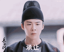 a man wearing a black hat and a shirt with chinese writing on it