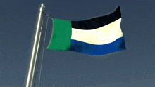 a green white and blue flag waving in the wind