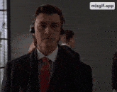 a man in a suit and tie is wearing headphones and a misgif.app logo is visible in the corner