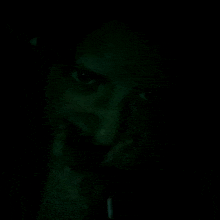 a close up of a person 's face in the dark with headphones on .