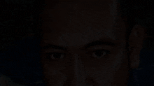 a close up of a man 's face with a dark background