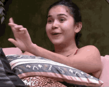 a woman is sitting on a couch with a pillow and making a face