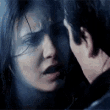 a man and a woman are looking at each other in the dark .