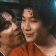 a couple of men are kissing each other on the cheek .