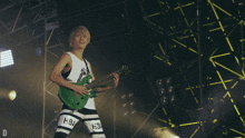 a man playing a guitar with hba on his shorts