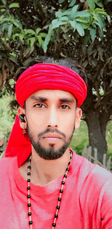 a man wearing a red headband and a red shirt is looking at the camera