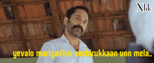 a man with a mustache is talking to another man with the words yevalo mariyadhai vechirukkaaan unn mela