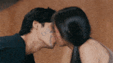 a man and a woman kissing with a drawing of a heart on the man 's face