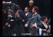 a group of people are dancing in a dark room and the word confetti is on the bottom
