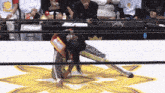 a wrestler is kneeling down in front of a crowd wearing a t-shirt that says ' tokyo '