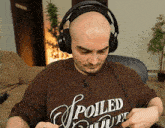 a man wearing headphones and a spoiled t-shirt