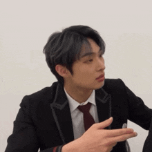 a man in a suit and tie is pointing
