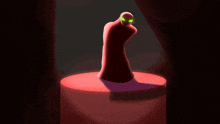 a statue of a person with green eyes standing on a red pedestal