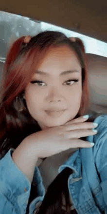 a woman with red hair is sitting in the back seat of a car .