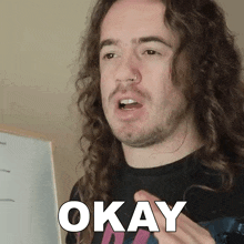 a man with long curly hair and a nose ring says okay