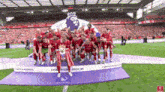 a group of soccer players are posing for a picture on a field