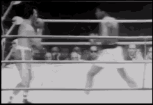 two boxers are fighting in a boxing ring in front of a crowd .