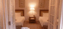 a bedroom with two twin beds and a lamp on the nightstand