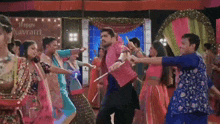 a group of people are dancing together in front of a sign that says happy navratri