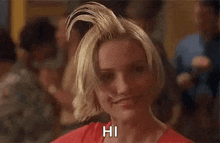 a woman with a mohawk on her head is smiling and says hi .