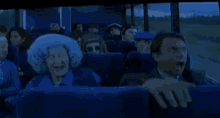 a man and woman are sitting on a bus with their mouths open