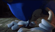 a close up of a blue cartoon character laying on a wooden table .
