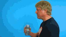 a man wearing a black shirt with a rolling stones logo is holding something in his fist in front of the word crushed