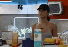 a woman standing in a kitchen with a carton of milk