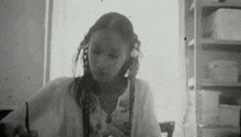 a woman is sitting at a table in a black and white photo .