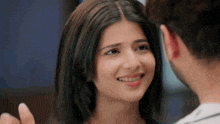 a close up of a woman smiling at a man while looking at him .