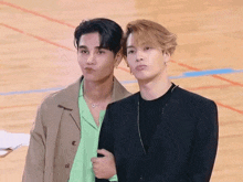 two men standing next to each other on a basketball court