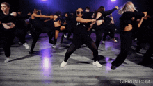 a group of women are dancing on a dance floor with gifrun.com at the bottom of the screen