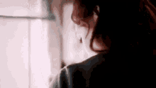 a close up of a woman 's face looking out of a window .