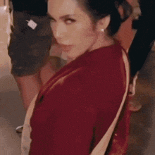 a woman in a red sweater is walking down a street .