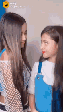 two girls are looking at each other and smiling .