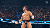 a wrestler is dancing in front of a crowd at a wrestling event