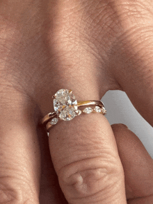 a woman wearing a ring with a diamond on it