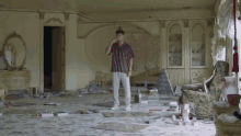a man in a striped shirt stands in an empty room