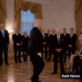 a man in a suit is dancing in front of a group of men in suits and ties with the words dark horse below him