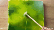 a person is painting a dandelion with a brush on a green background