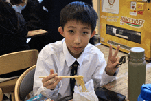 a boy eating noodles with chopsticks in front of a joint host machine