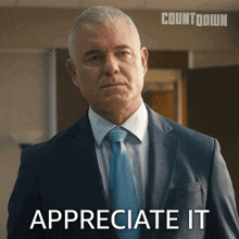 a man in a suit and tie says " appreciate it " in front of a countdown logo