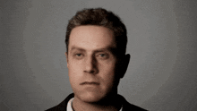a man 's face is shown from the side with a gray background