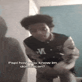 a young man in a varsity jacket is standing in a room and talking to a woman .