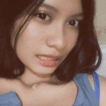 a close up of a woman 's face wearing a blue shirt