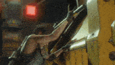 a woman in a video game is reaching into a machine with a red light behind her