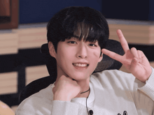 a young man giving a peace sign with his hands