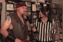 a man in a pirate costume is being interviewed by a woman wearing a striped shirt